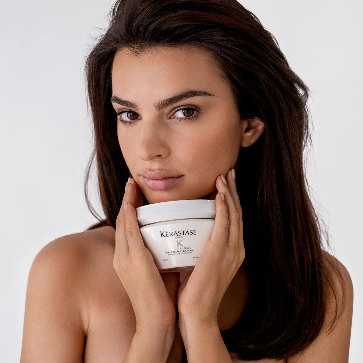 Emily Ratajkowski holding a Kerastase hair masque